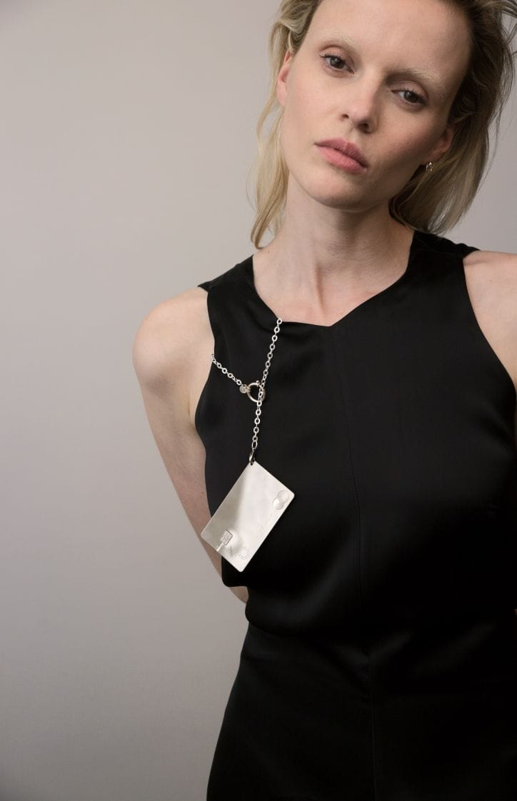 A girl wears a Saskia Diez lovers credit card on her black dress