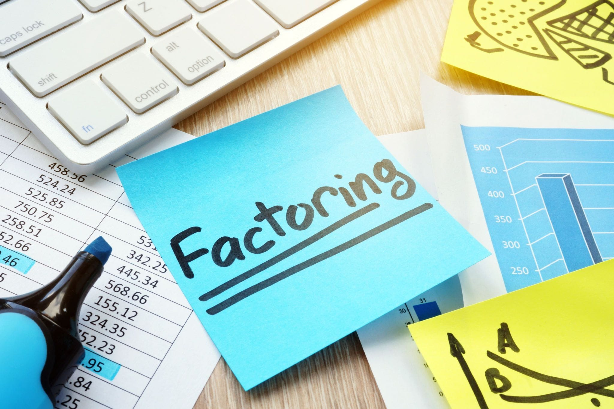 Post-it note with "factoring" written on it near a computer