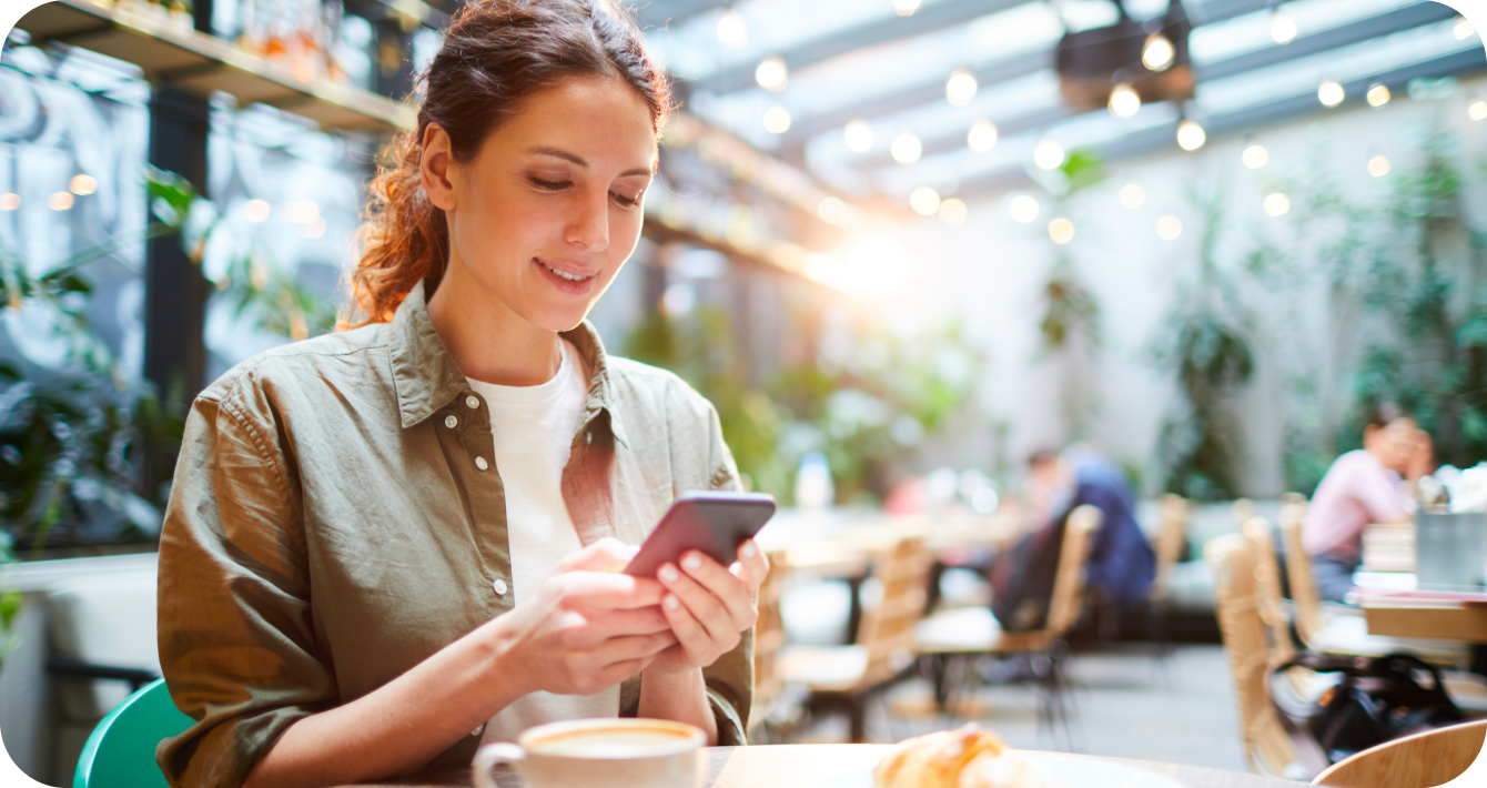 Photo of a relaxed woman texting her registered dietitian while at a café
