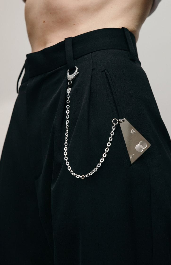 A man wears a Saskia Diez lovers payment card hung to his pant