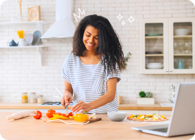 Photo of a happy young woman chopping vegetables for a healthy, balanced meal