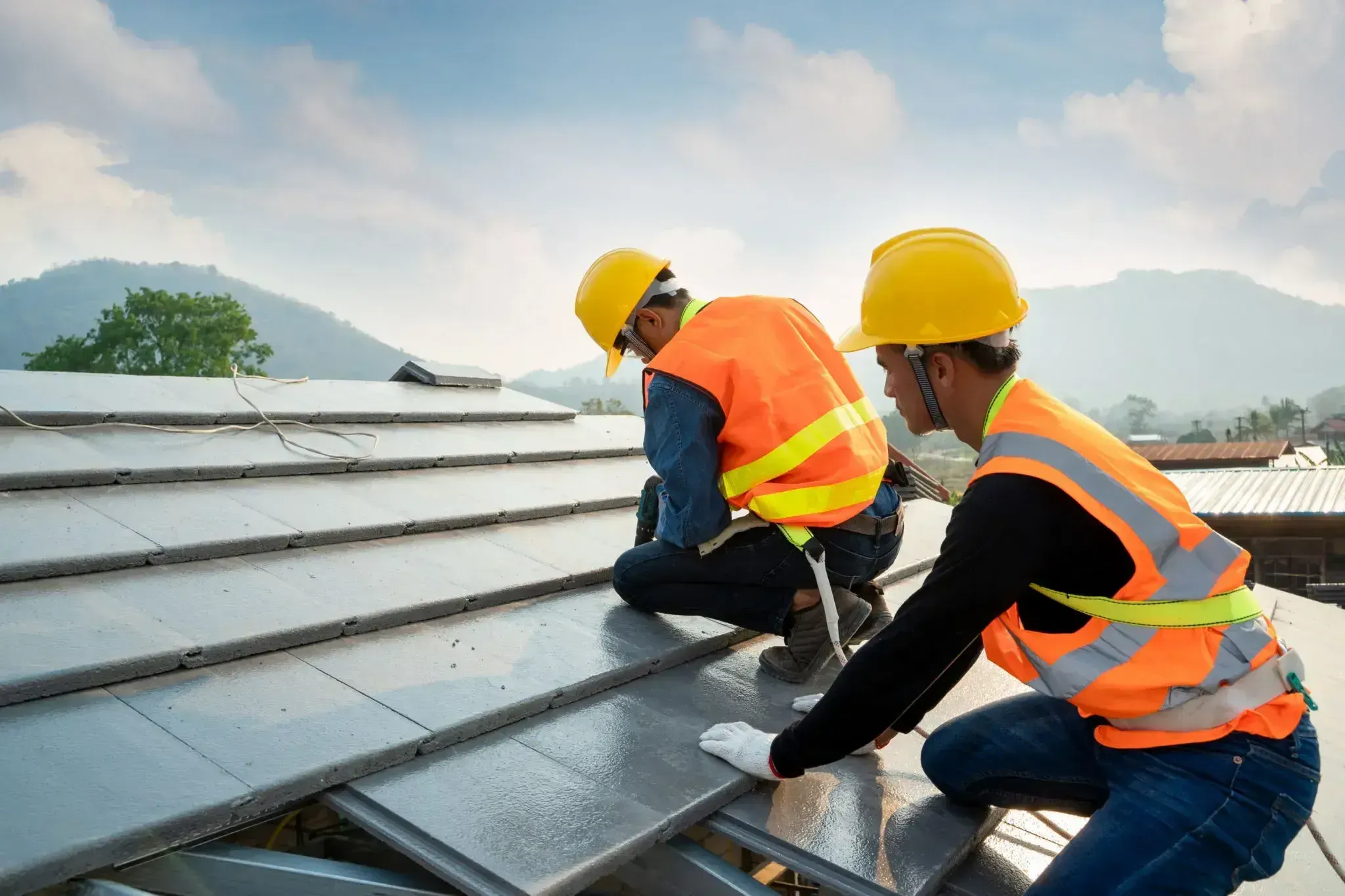 Roofers working on roof of construction project