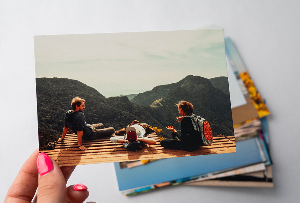 Hand holding a Stampix classic photo print with more classic prints in the background