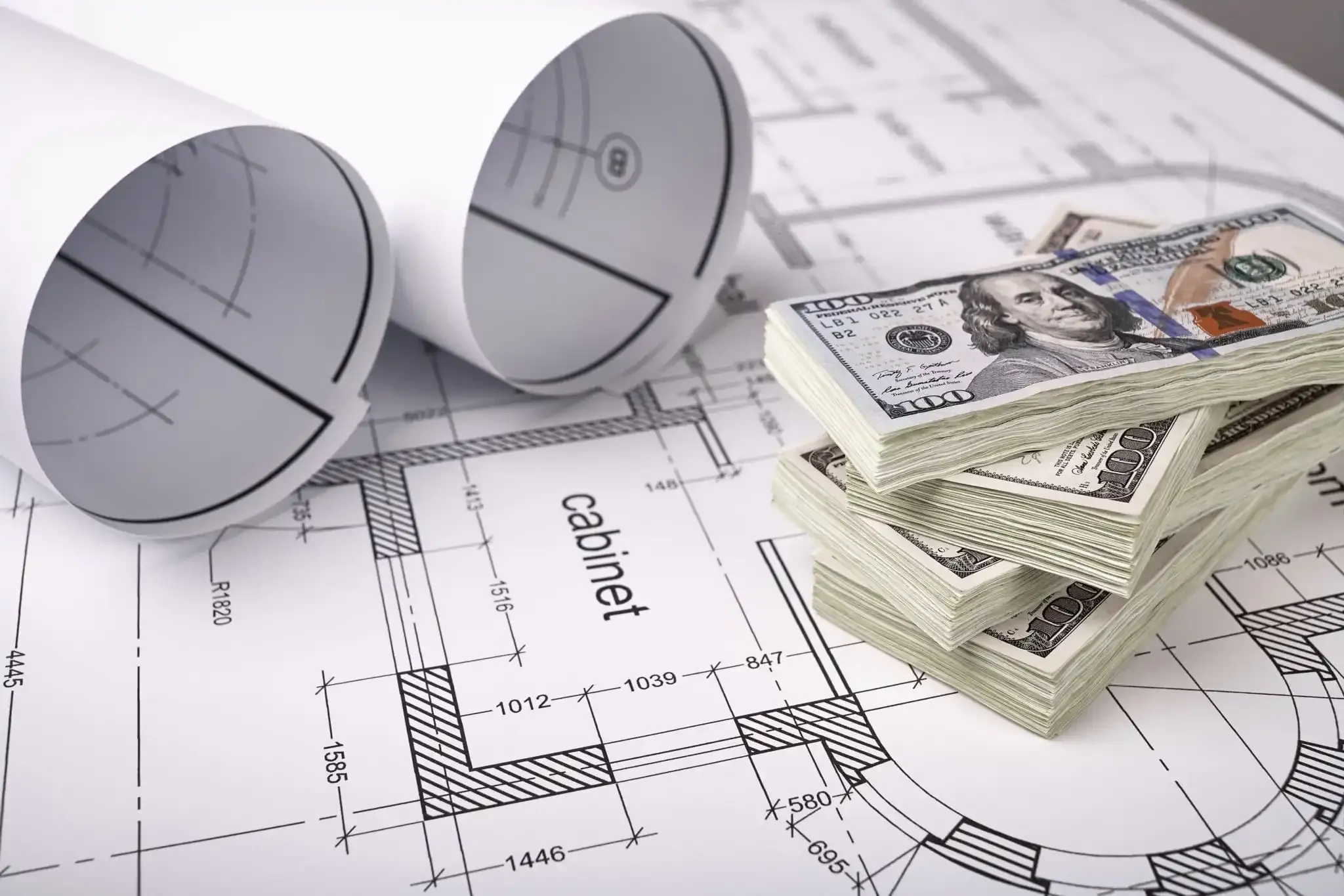 Money resting on construction plans