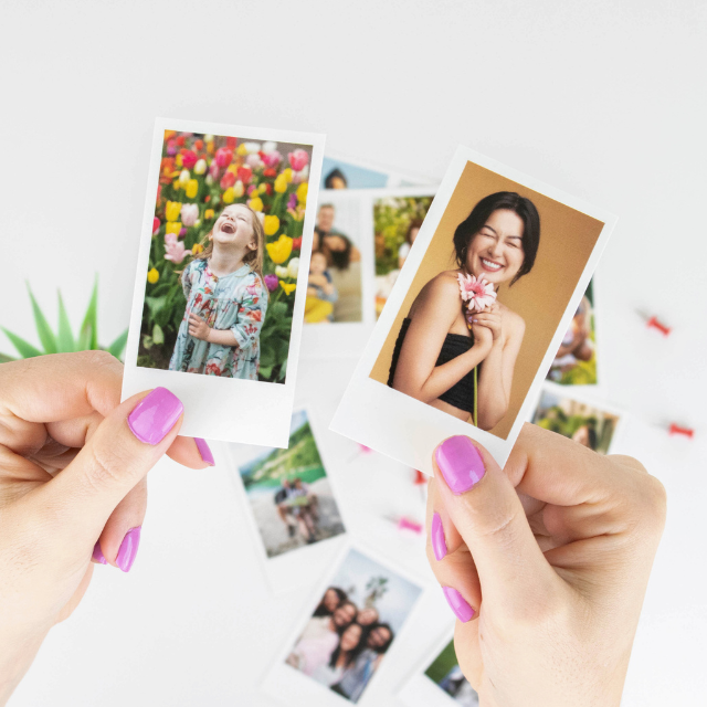 Hand holding a card containing two Stampix mini photo prints