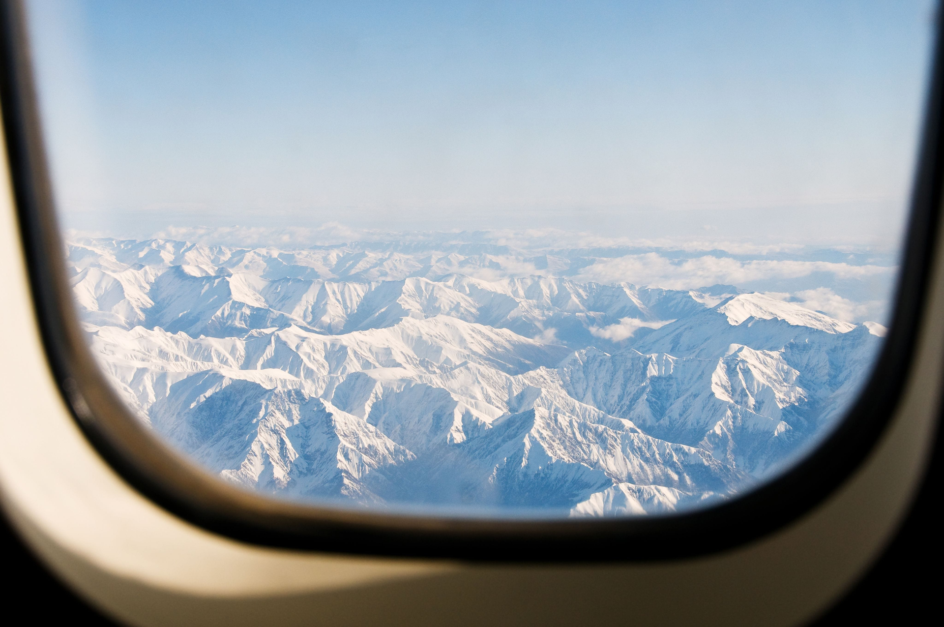 Air Canada airplane in flight over mountains at sunset.