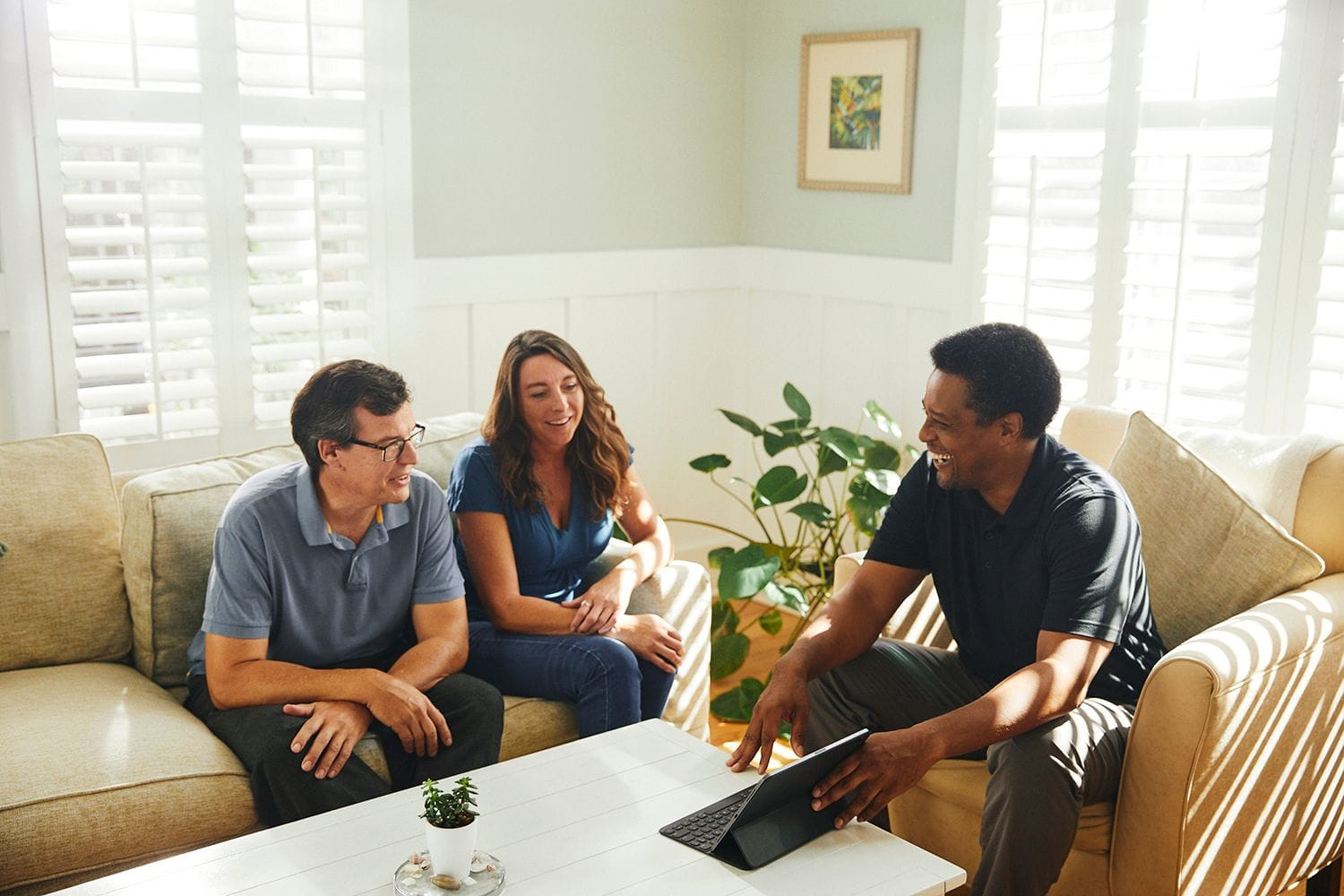 HVAC dealer sitting inside a home with two potential customers