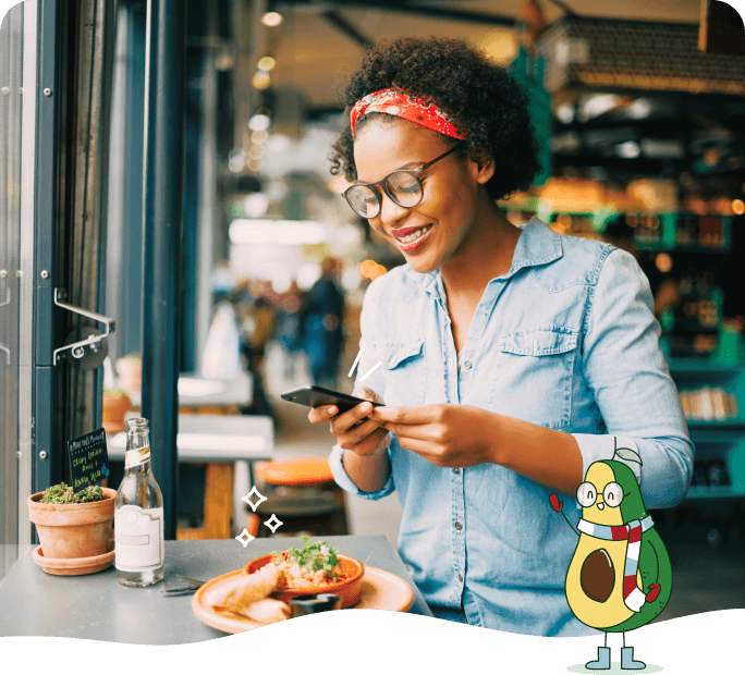 Photo of a happy woman using her phone at a restaurant