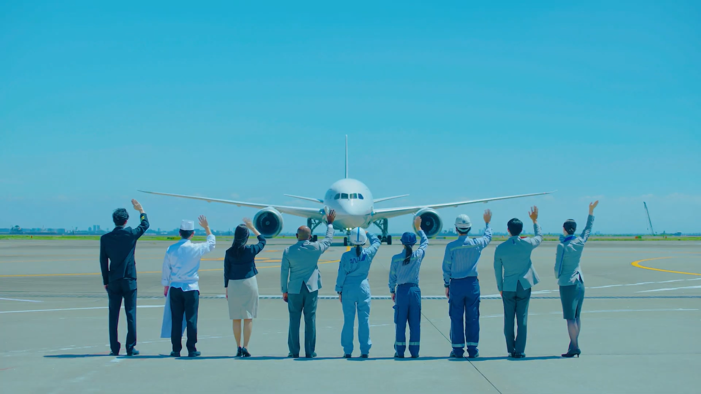 ANA crew greeting an arriving plane on the runway