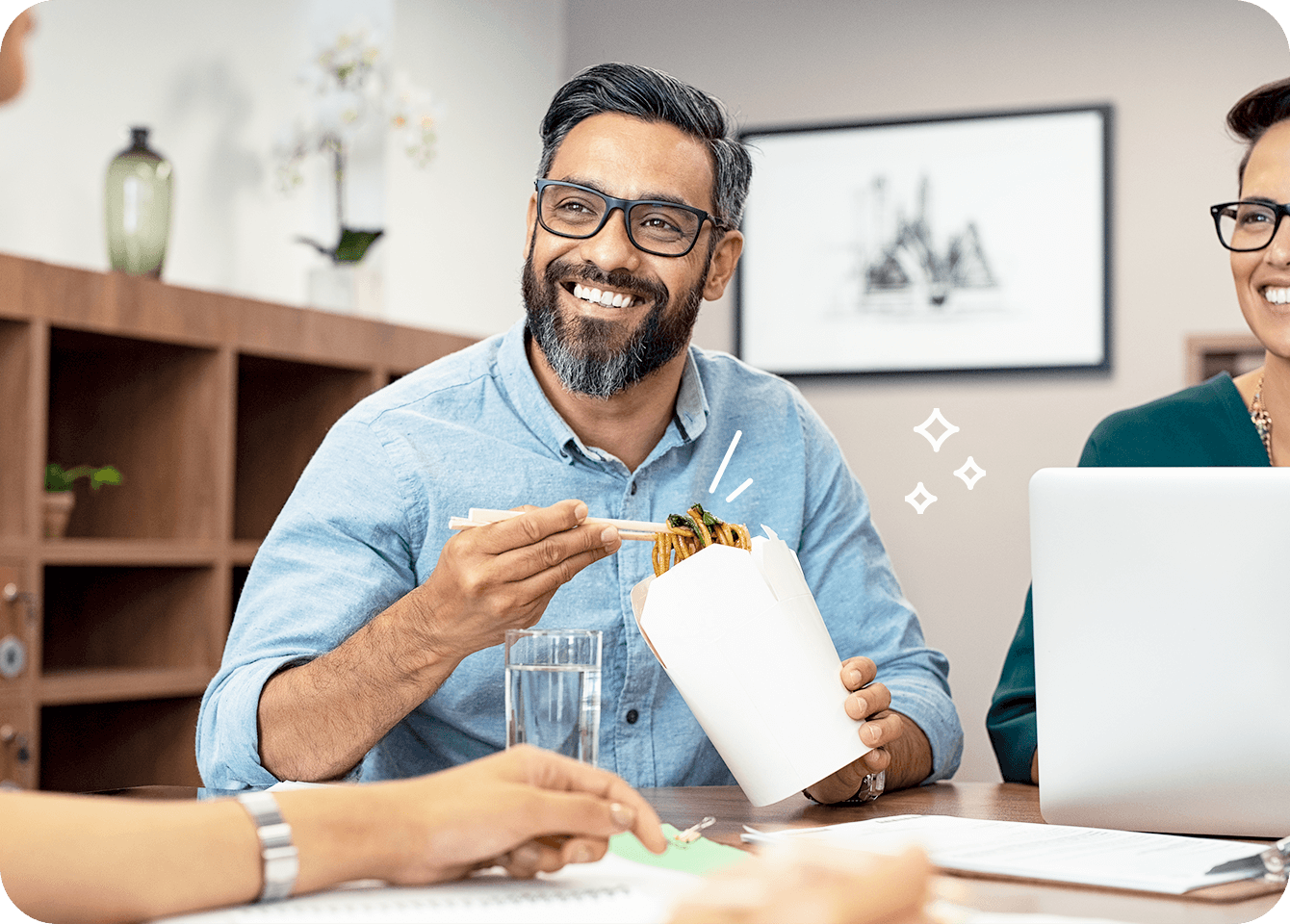 Photo of a happy man eating a meal at work