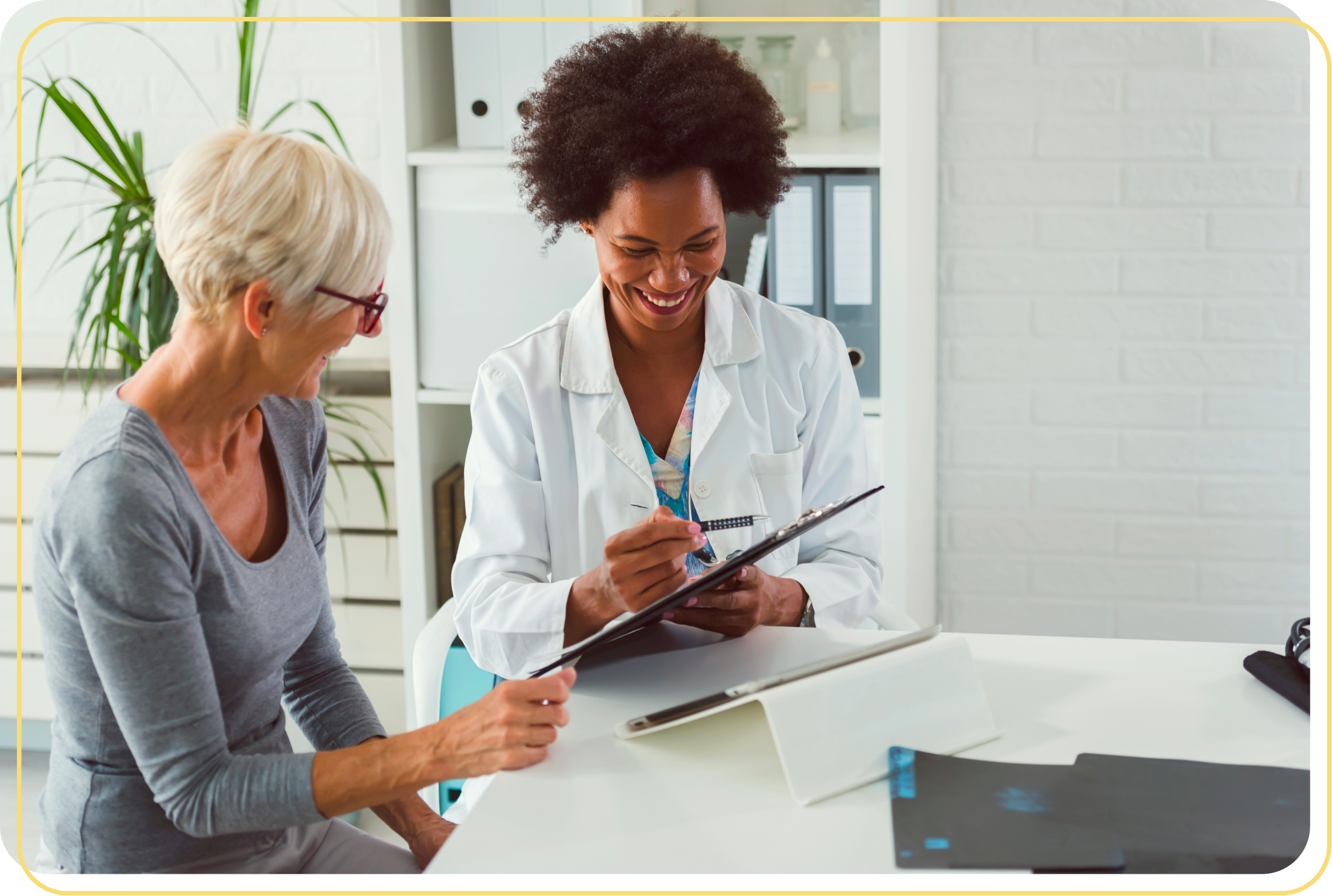 Photo of a woman and her doctor happily discussing medical progress