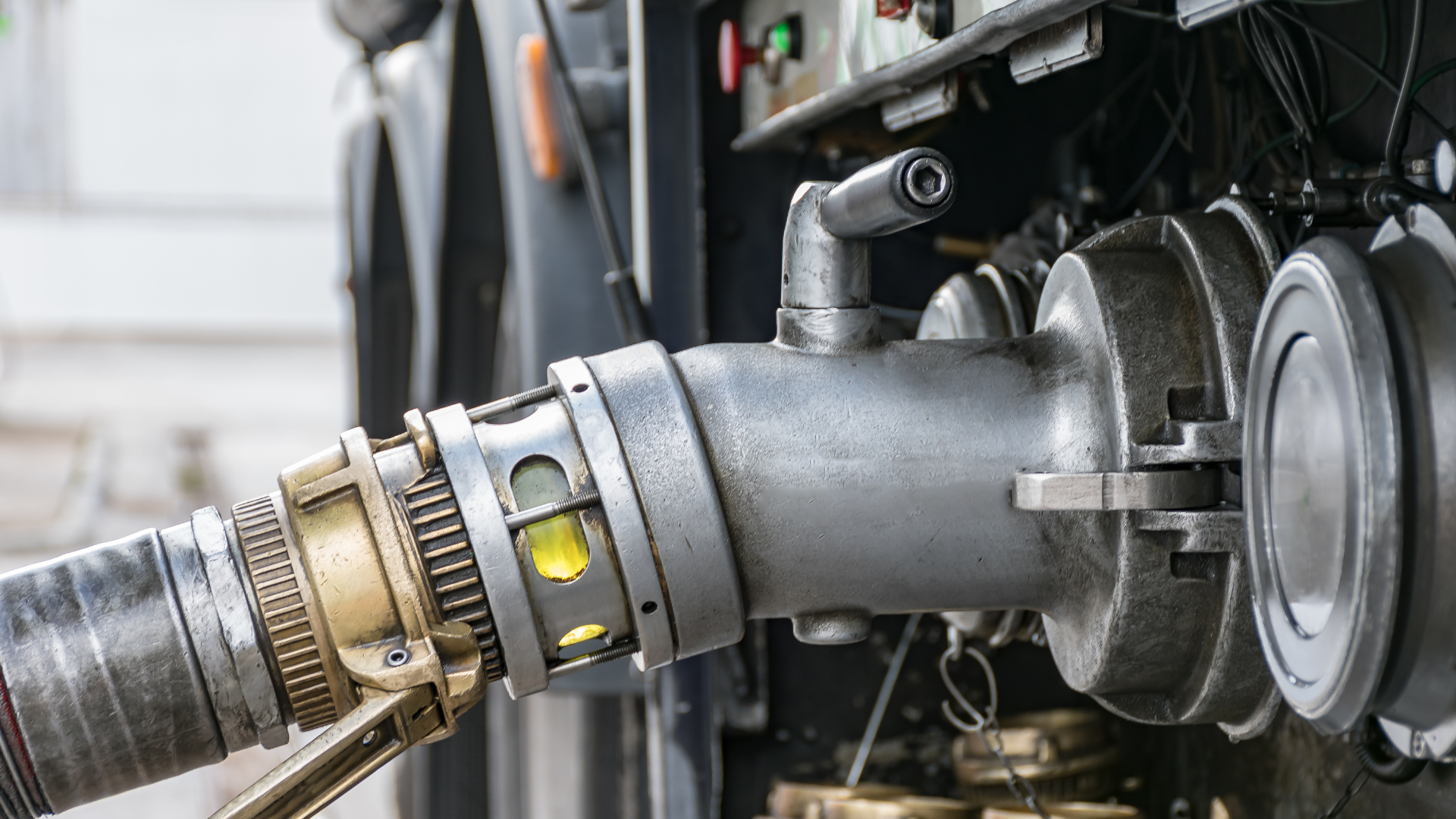 Close-up of a fuel hose connected to an aircraft refueling port.
