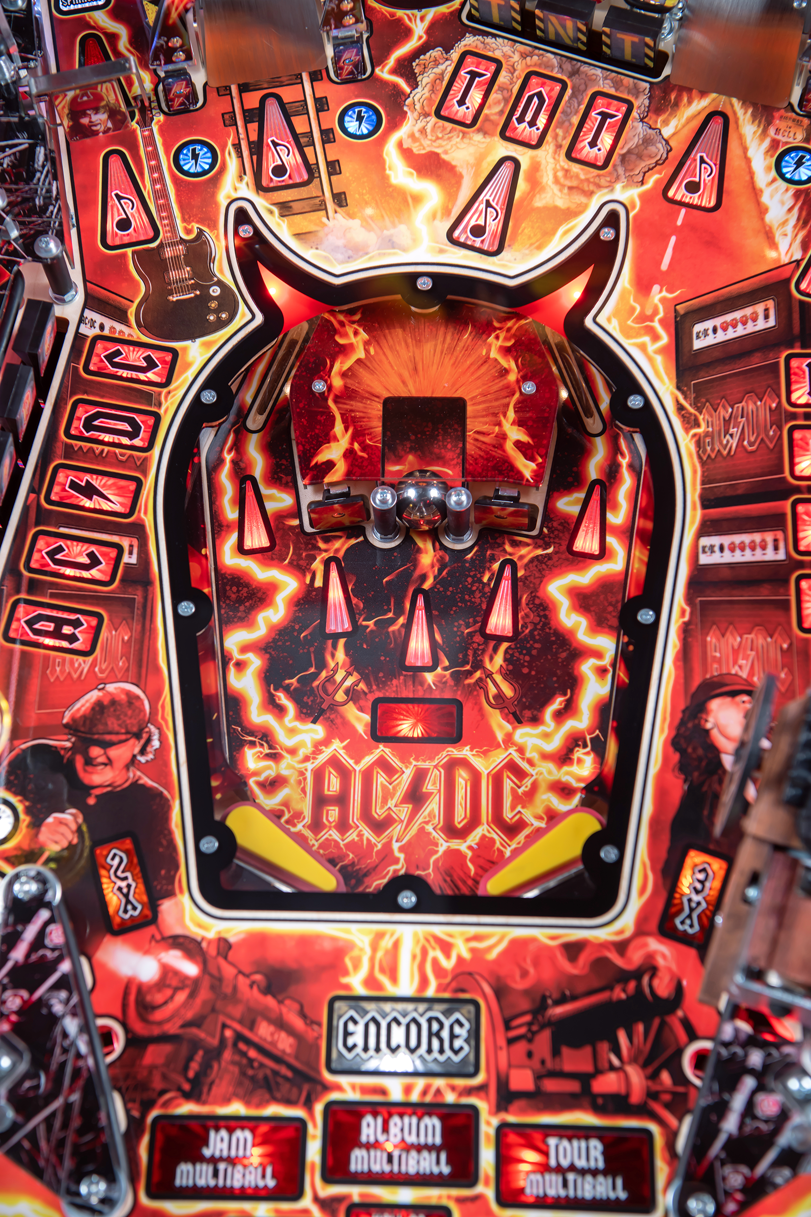 A lower playfield with illuminated inserts on  the AC/DC Remastered pinball machine by Stern Pinball.