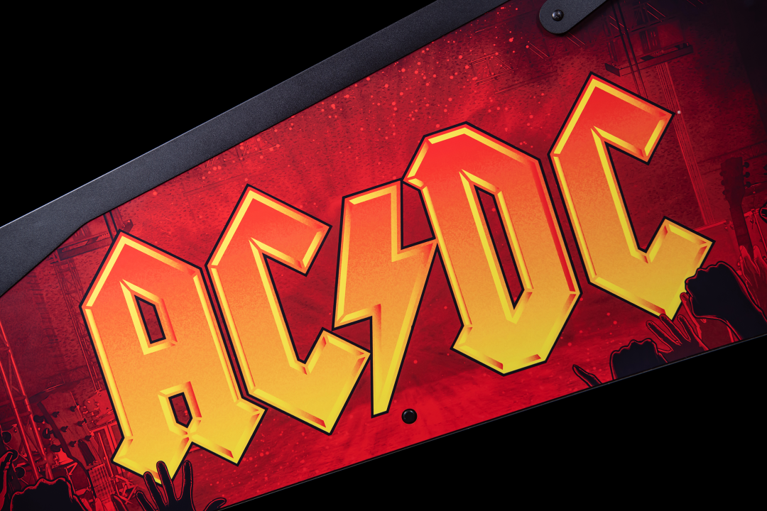 Side artwork featuring the logo from AC/DC on A lower playfield with illuminated inserts on the AC/DC Remastered pinball machine by Stern Pinball.