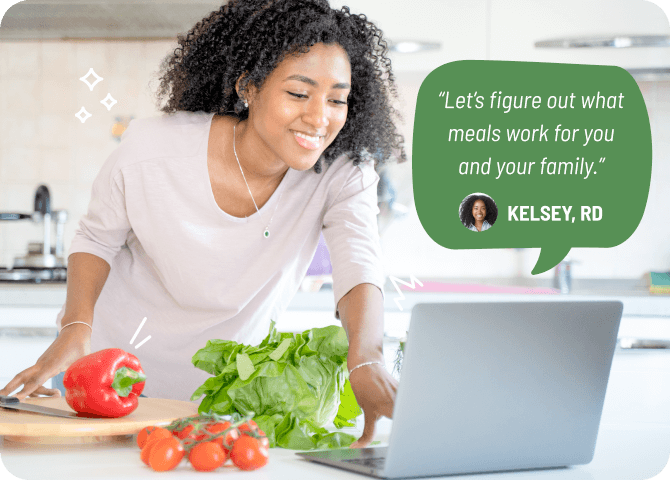 Photo of a smiling woman preparing a meal for her family while on a video chat with her registered dietitian