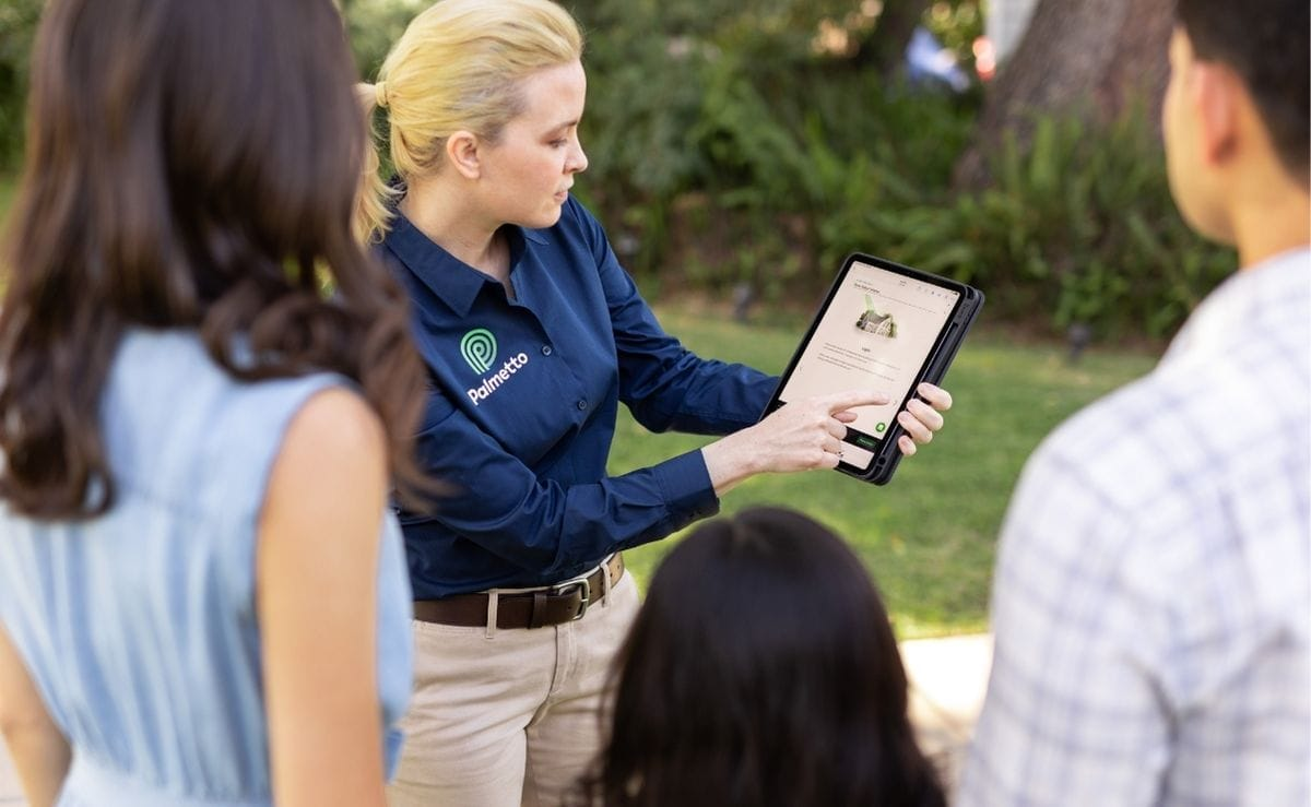 Un representante de ventas de Palmetto Solar muestra una propuesta a un cliente