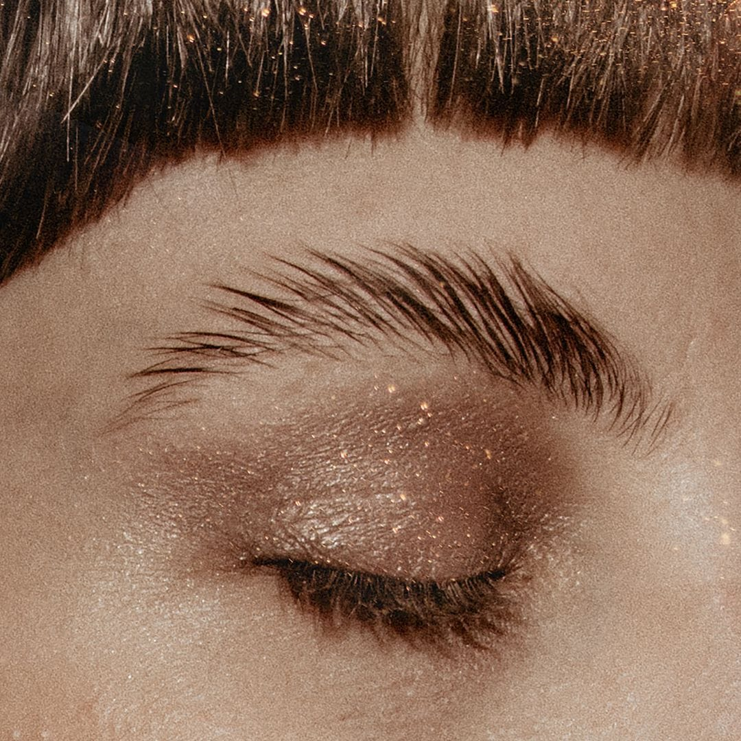 Close up on a person's face and closed eye with gold glitter eyeshadow
