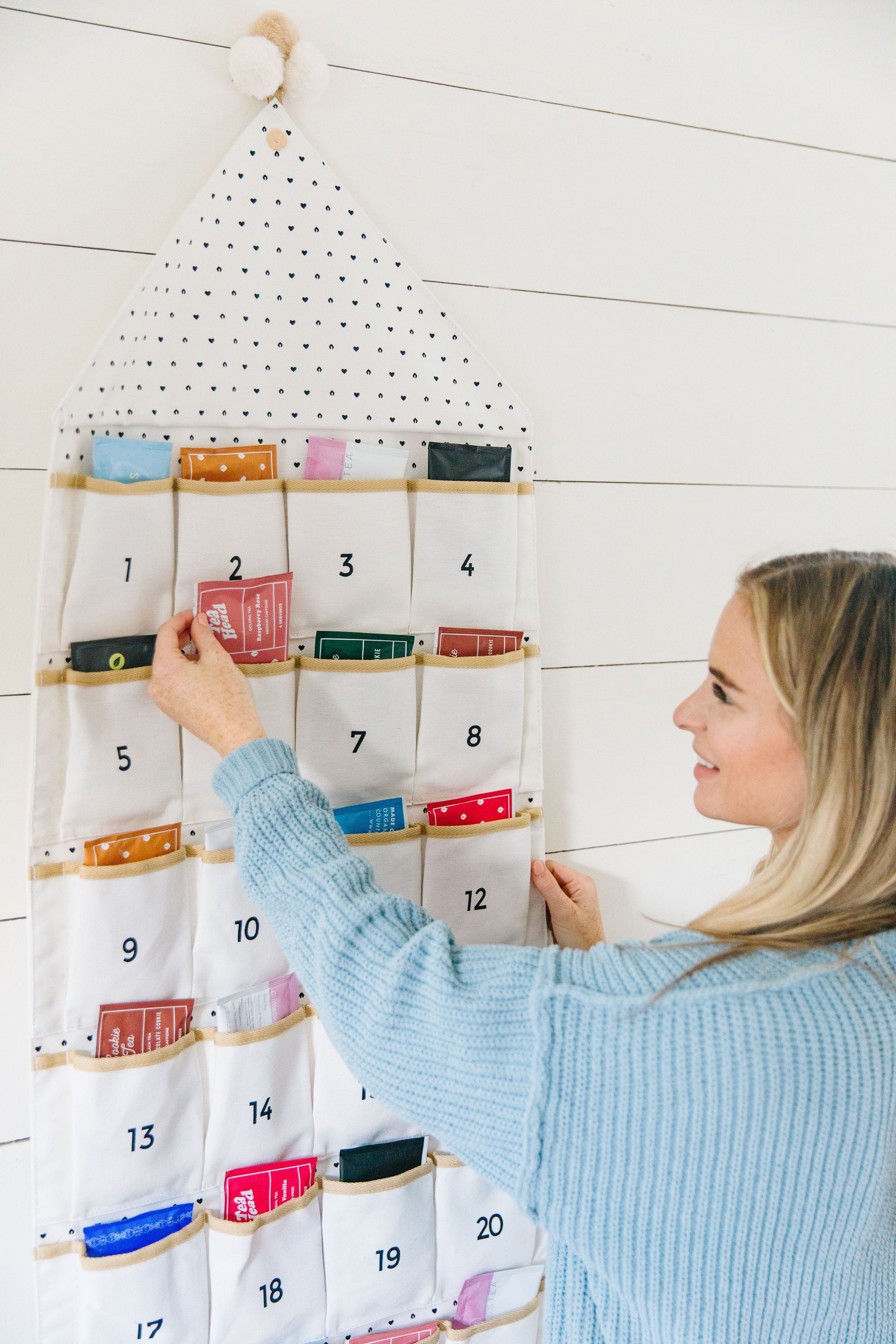 Woman picking out day 6 tea from 24-day white holiday tea advent calendar from Sips by