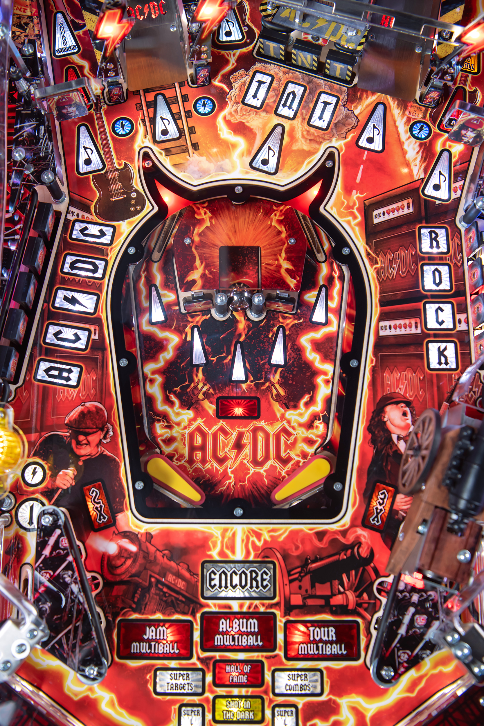 A lower playfield with illuminated inserts on the AC/DC Remastered pinball machine by Stern Pinball.