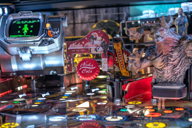 A spinning bottle cap labeled 'Nuka Cola' in the center of the playfield of the Fallout Pinball machine by Stern.
