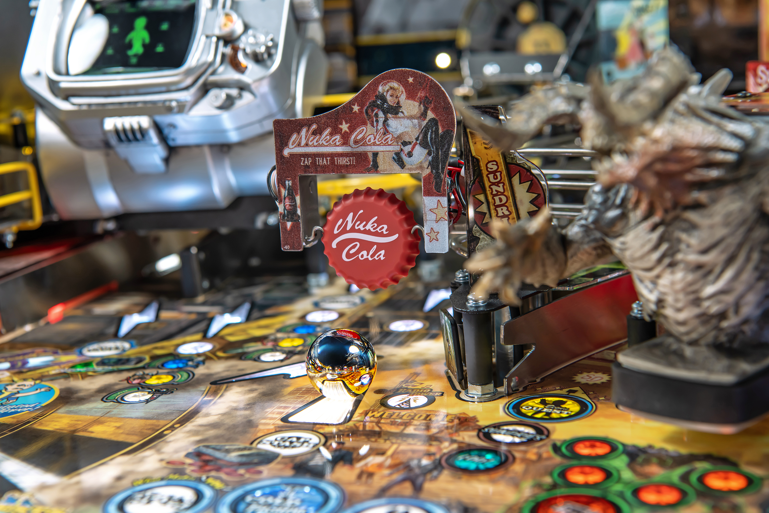 A spinning bottle cap labeled 'Nuka Cola' in the center of the playfield of the Pro Model of Fallout Pinball by Stern.
