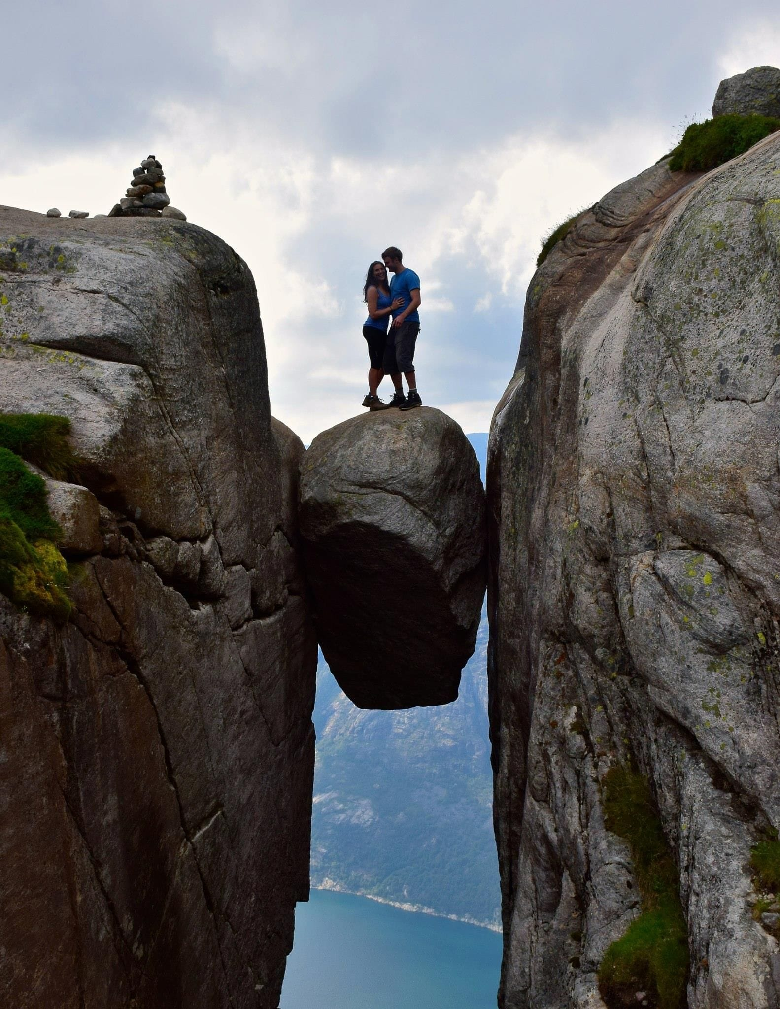 Staci Brinkman and Øivind Loe standing on Kjeragbolten rock in Norway