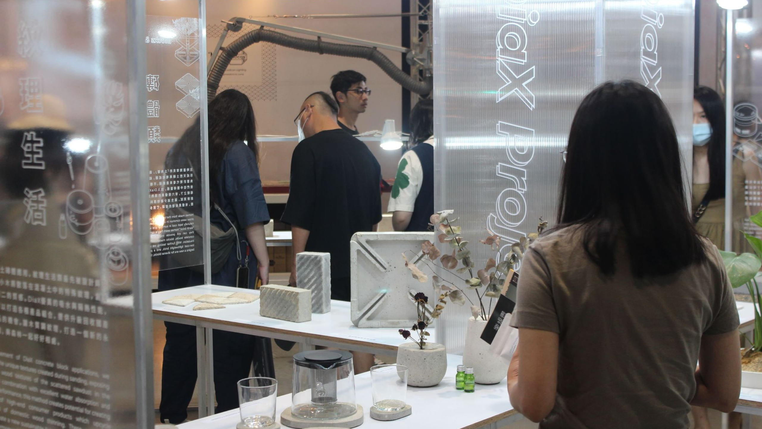 several people have their back to the camera and are touching and examining various exhibition products and prototypes